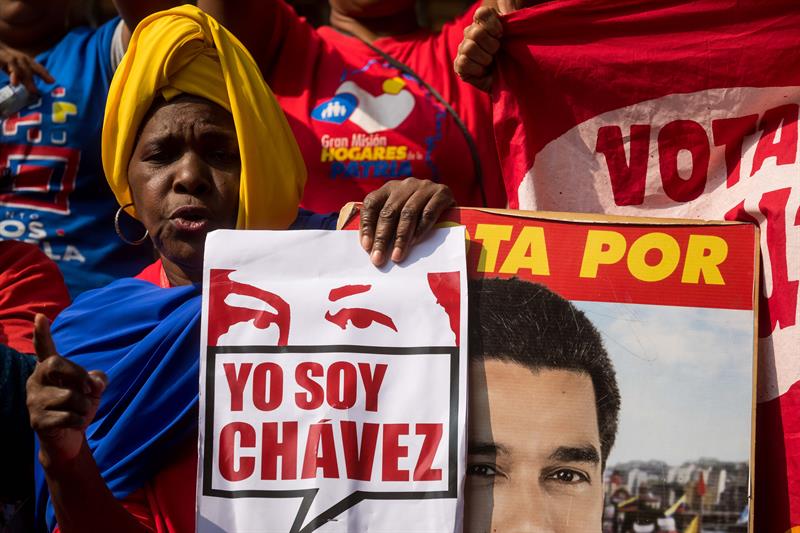 Una mujer sostiene un letrero durante una concentración en las inmediaciones del palacio de Miraflores para conmemorar el quinto aniversario del fallecido presidente venezolano Hugo Chávez, el pasado lunes 5 de marzo, en Caracas, Venezuela. Foto: Miguel Gutiérrez, EFE