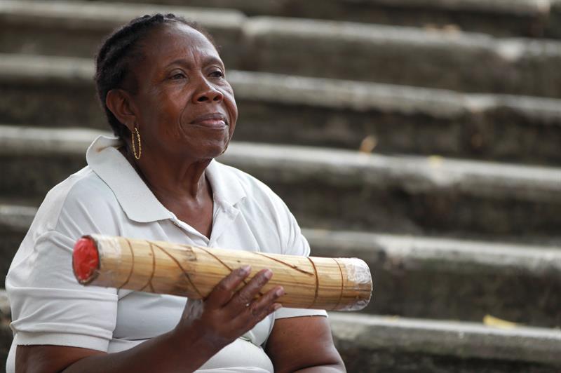 Una mujer toca un instrumento, en Cali, Colombia. Foto: Ernesto Guzmán Jr., EFE