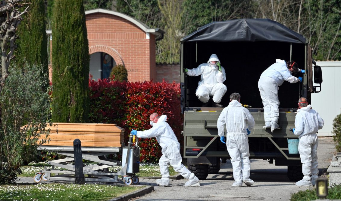 21/03/2020 dpatop - 21 March 2020, Italy, Ferrara: People in protective suits transport a coffin with a corpse of the deceased due to the coronavirus in the cemetery of Ferrara. Military vans are having to transport coffins from Bergamo to other Italian cities, as the city, hard-hit by the coronavirus, has long run out of space for the many Covid-19 dead. Photo: Massimo Paolone/LaPresse via ZUMA Press/dpa POLITICA INTERNACIONAL Massimo Paolone/LaPresse via ZUM / DPA