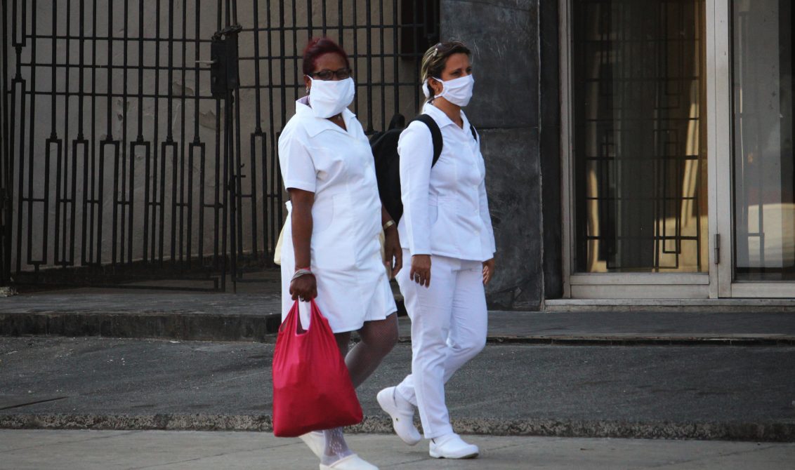 04/04/2020 04 April 2020, Cuba, Havana: Two nurses wearing face masks walk through the city amid the spread of the coronavirus. Cuba has sealed off a part of downtown Havana popular with tourists because of the Coronavirus pandemic. Photo: Guillermo Nova/dpa POLITICA INTERNACIONAL Guillermo Nova/dpa