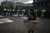 (200626) -- BOGOTA, 26 junio, 2020 (Xinhua) -- Una joven indígena porta una mascarilla mientras sostiene un cartel durante una manifestación tras la violación de una adolescente indígena, frente al Monumento a Los Soldados Caidos, en la ciudad de Bogotá, Colombia, el 26 de junio de 2020. El fiscal general de Colombia, Francisco Barbosa, anunció el jueves que los siete militares que violaron a una adolescente indígena de 14 años dentro de un cabildo aborigen fueron enviados a la cárcel tras reconocer su delito. (Xinhua/Jhon Paz) (jhp) (vf) (dp)
