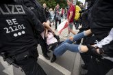 01 August 2021, Berlin: Policemen detain a woman taking part in an unannounced demonstration against the Coronavirus measures despite a ban on protests. Photo: Fabian Sommer/dpa