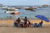 Acapulco,Gro/120Octubre2021/ Un dueto de músicos norteños le cantan a una familia de vacacionistas en la playa de Caleta en Acapulco, la tarde de ayer. Foto: Jesús Trigo