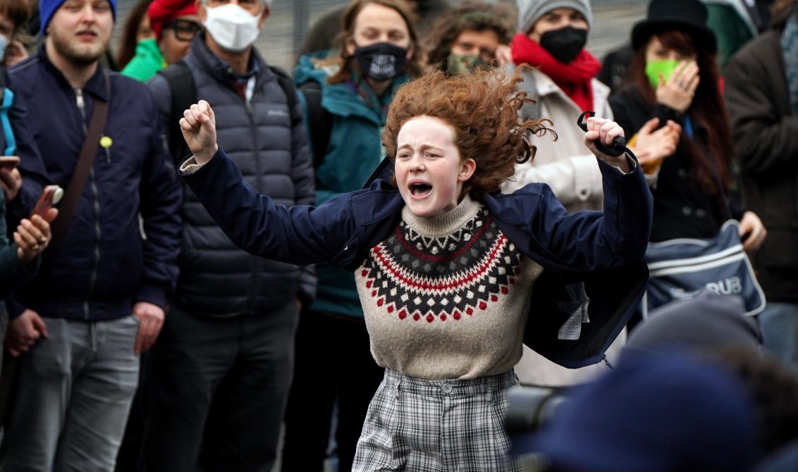12 November 2021, United Kingdom, Glasgow: A climate activist dances during a protest on the final day of the United Nations Climate Change Conference (COP26). Photo: Andrew Milligan/PA Wire/dpa