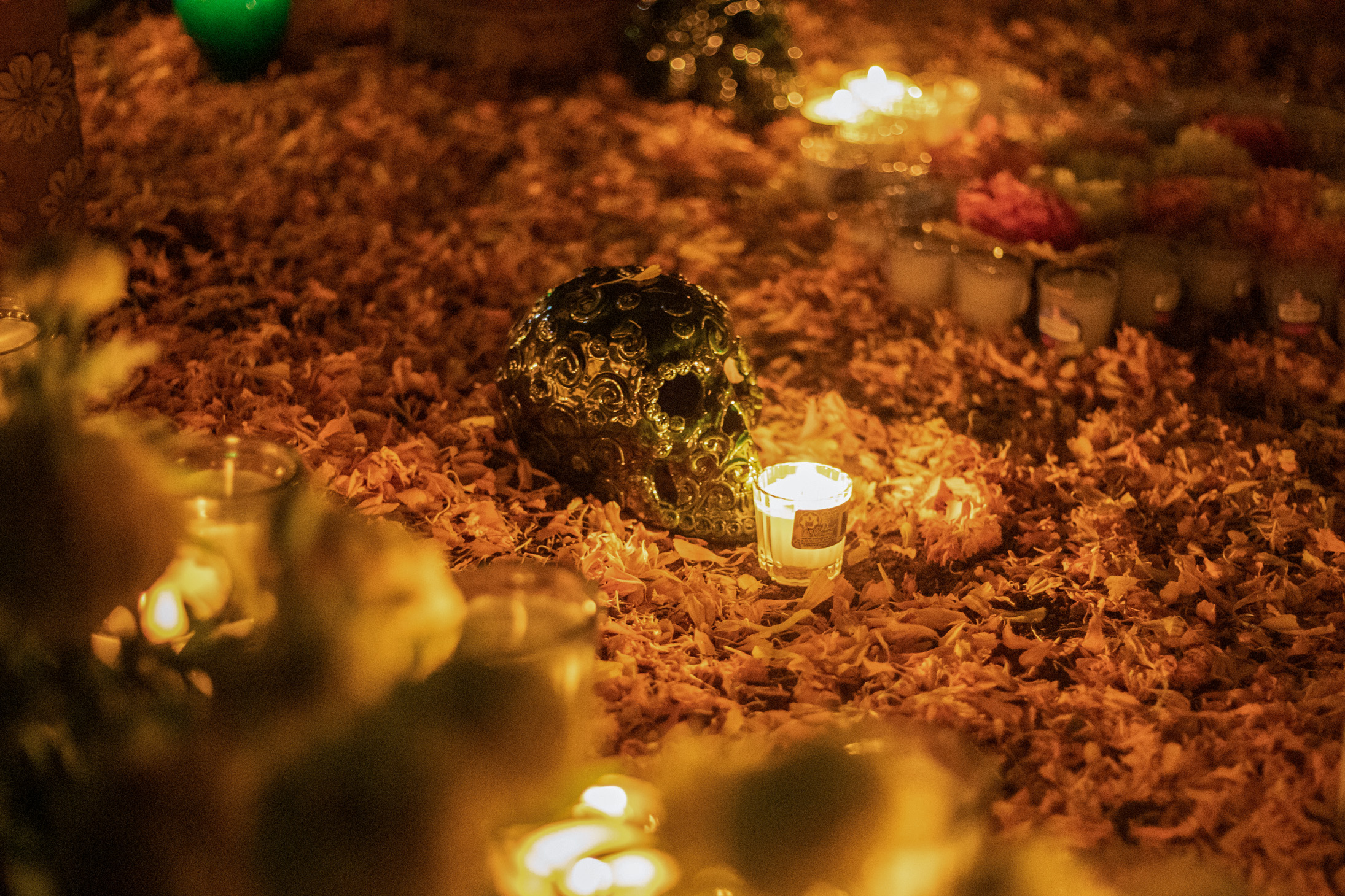 31 October 2022, Mexico, Oaxaca: Candles burn around an ornament skull at a decorated cemetery on All Saints' Day which celebrates the Day of the Dead. Photo: Felipe Perez/dpa