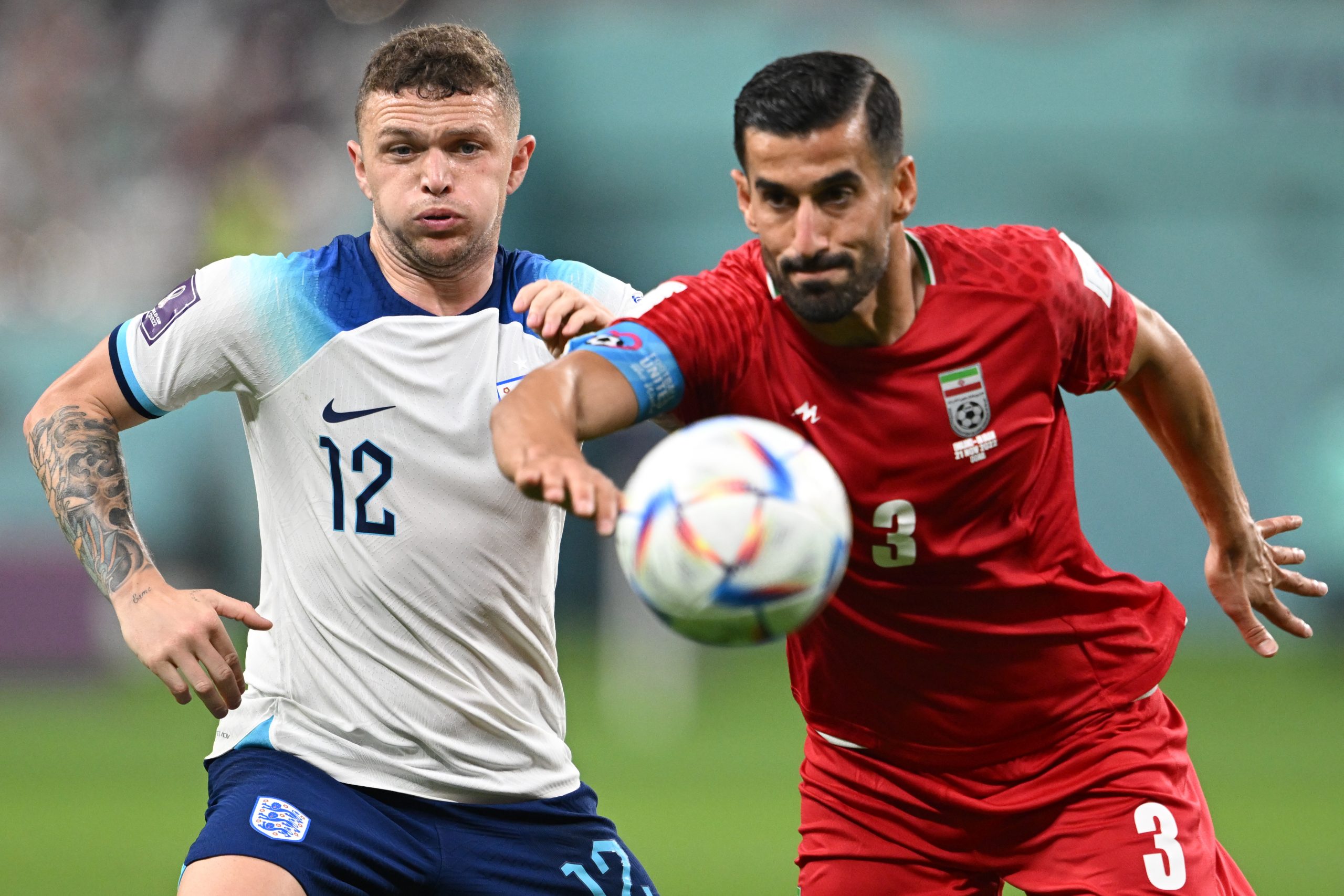 21 November 2022, Qatar, Doha: England's Kieran Trippier (L) and Iran's Ehsan Hajsafi battle for the ball during the FIFA World Cup Qatar 2022 Group B soccer match between England and Iran at Khalifa International Stadium. Photo: Robert Michael/dpa