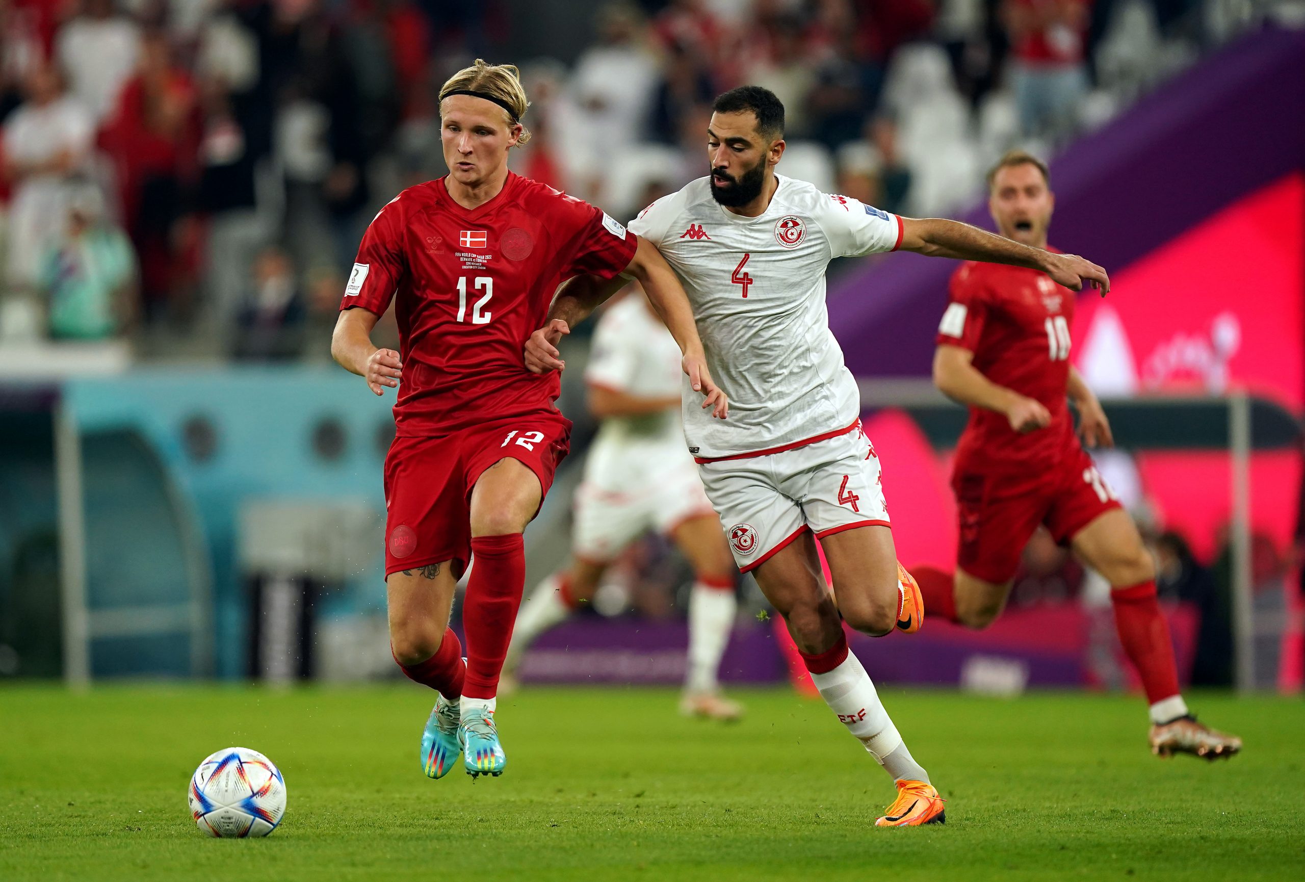 22 November 2022, Qatar, Al Rayyan: Denmark's Kasper Dolberg (L) and Tunisia's Yassine Meriah battle for the ball during the FIFA World Cup Qatar 2022 Group D soccer match between Denmark and Tunisia at the Education City Stadium. Photo: Mike Egerton/PA Wire/dpa