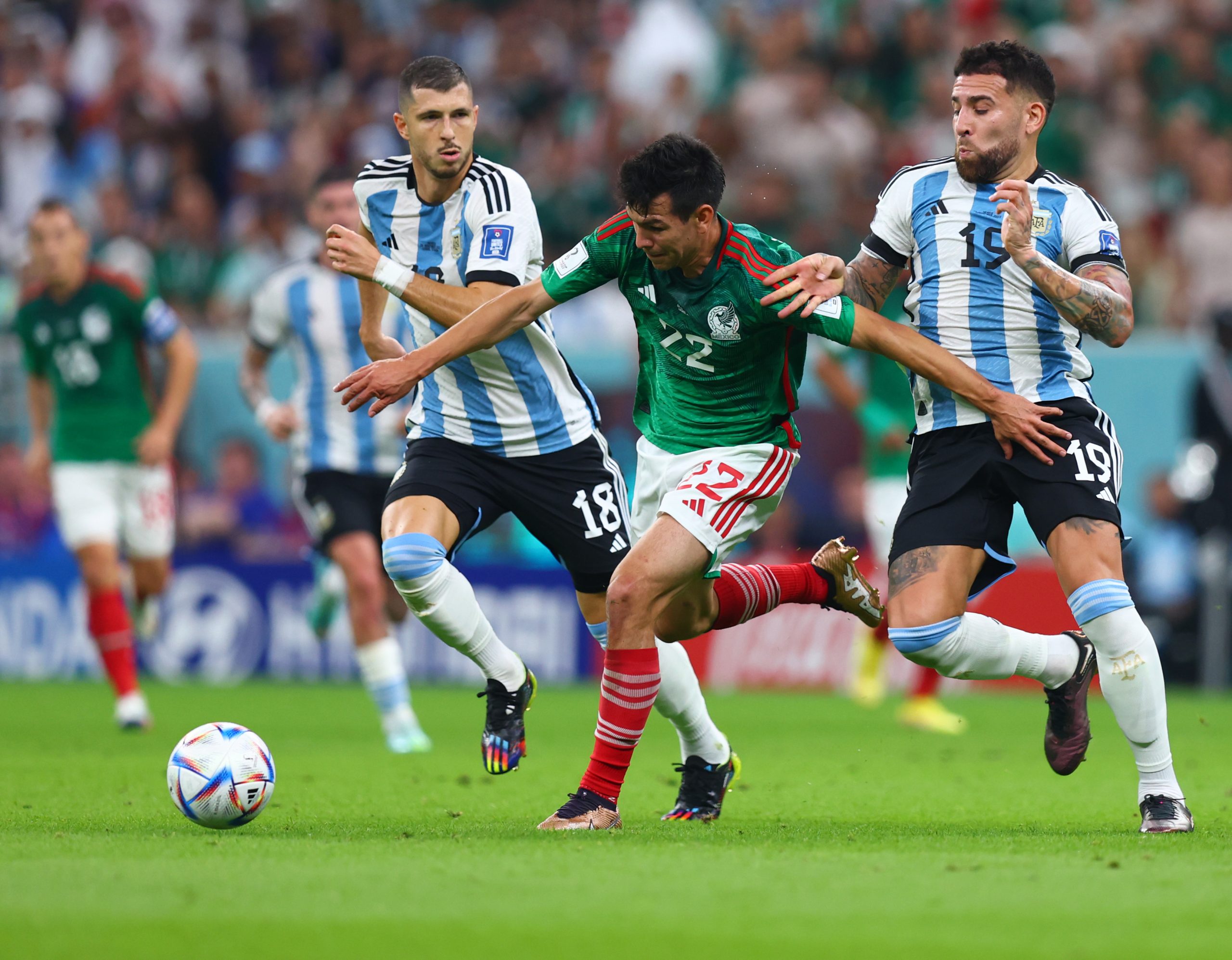 26 November 2022, Qatar, Lusail: Mexico's Hirving Lozano (C) battles for the ball with Argentina's Guido Rodriguez (L) and Nicolas Otamendi during the FIFA World Cup Qatar 2022 Group C soccer match between Argentina and Mexico at the Lusail Stadium. Photo: Tom Weller/dpa
