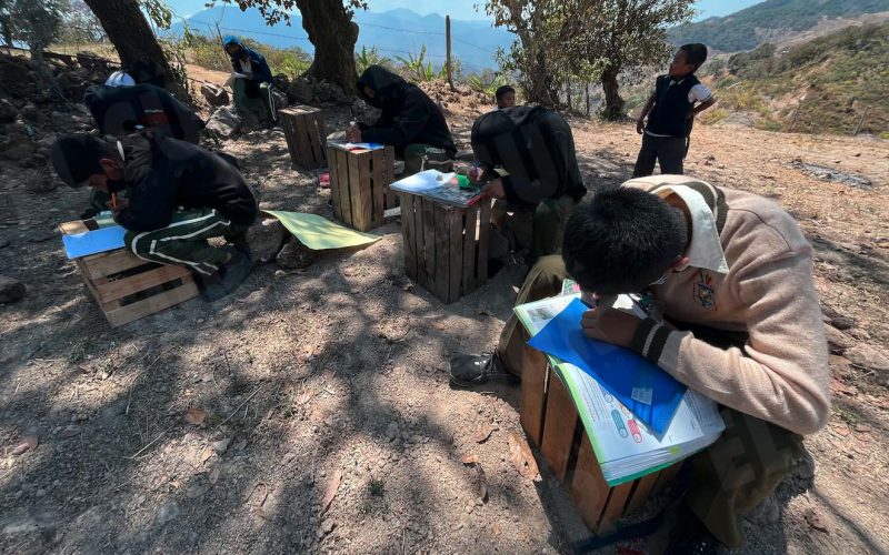 Alumnos de secundaria de la comunidad nahua de Ayahualtempa toman clases sentados en piedras y apoyados en cajas de madera en un terreno baldío, a pesar del compromiso hace seis meses de los gobiernos estatal y federal de hacer la escuela. Foto: Lenin Ocampo