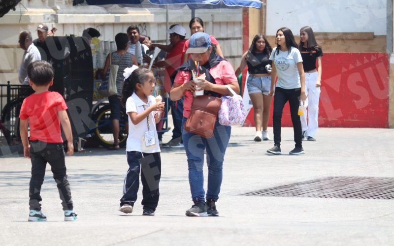 Las altas temperaturas en Chilpancingo hacen que los capitalinos busquen espacios con sombra, usen sombrillas y consuman aguas frescas o helados para hidratarse un poco. Foto: Jesús Guerrero