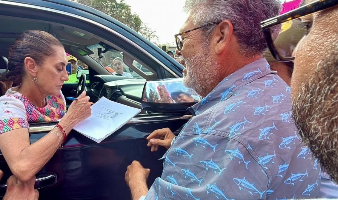 El presidente del Comité de Defensa del Muelle de Puerto Vicente Guerrero, José Martínez Espino entrega a la presidenta Claudia Sheinbaum el expediente en el que le solicitan que no los desalojen de la dársena para construir una base naval para la Secretaría de Marina-Armada de México. Foto: Cortesía: José Martínez