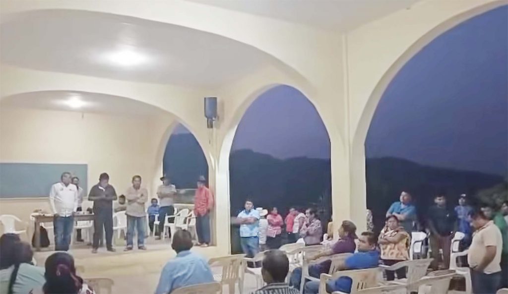 El alcalde de San Luis Acatlán, Adair Hernández Martínez (de camisa blanca al fondo a la izquierda) en la asamblea con vecinos de Buenavista, quienes lo retuvieron en la Comisaría para exigirle que autorice 20 millones de pesos para obras que le corresponden a esa comunidad. Fotograma de un video difundido ayer en Facebook