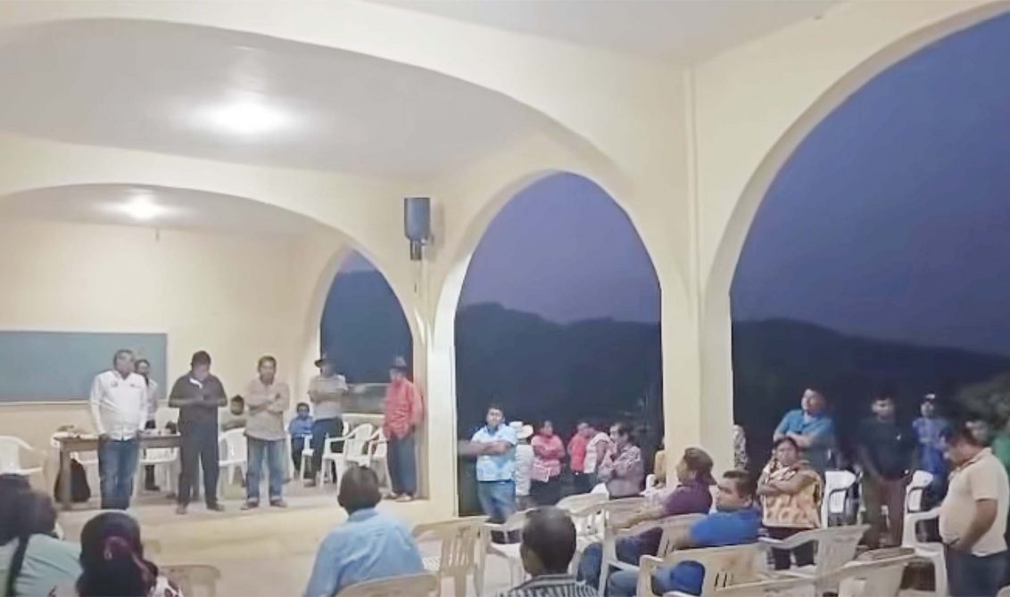 El alcalde de San Luis Acatlán, Adair Hernández Martínez (de camisa blanca al fondo a la izquierda) en la asamblea con vecinos de Buenavista, quienes lo retuvieron en la Comisaría para exigirle que autorice 20 millones de pesos para obras que le corresponden a esa comunidad. Fotograma de un video difundido ayer en Facebook